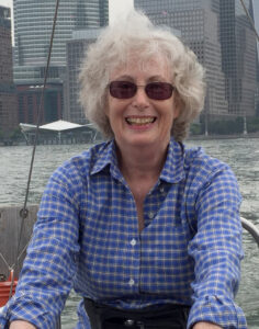 Marcy Robinson's smiling headshot on a sailboat