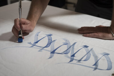 Massimo Polello writing in large brush letters