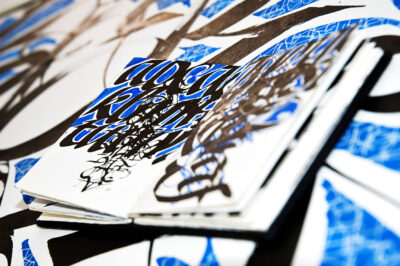 Blue and black lettering in sketchbook by Cláudio Gil